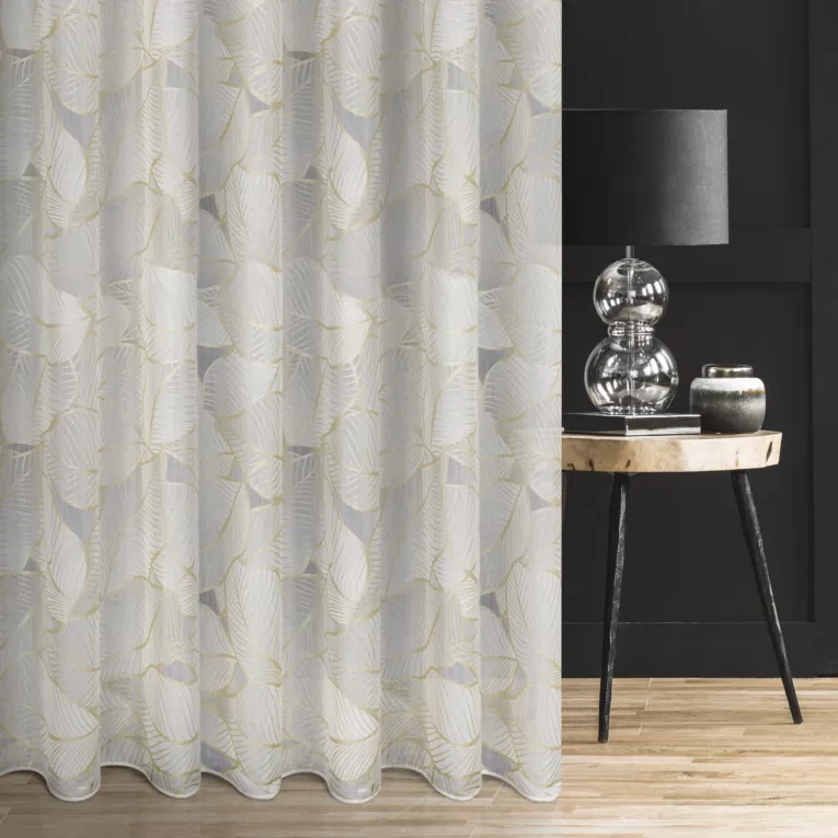 Firana szyta na taśmie 5 cm biało złota z tkaniny typu BATYST z delikatnie połyskującym nadrukiem w kształcie liści po całości tkaniny, wykończona obciążnikiem