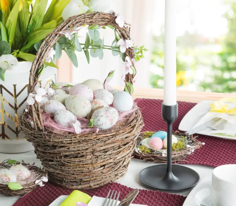 Wielkanocny koszyczek z pisankami wyplatany z naturalnych gałązek