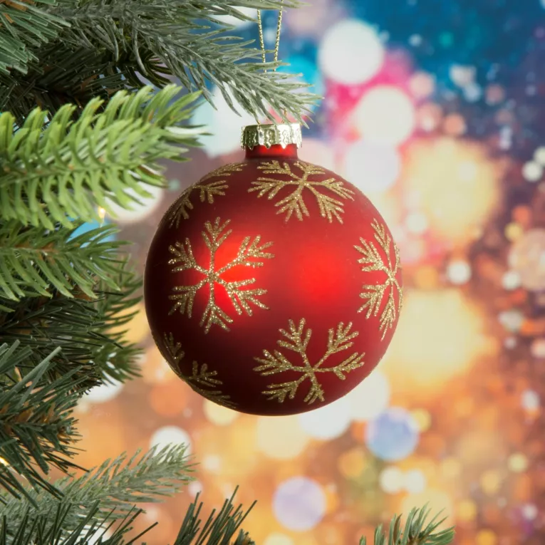 Szklana bombka ręczni zdobiona błyszczącymi śnieżynkami