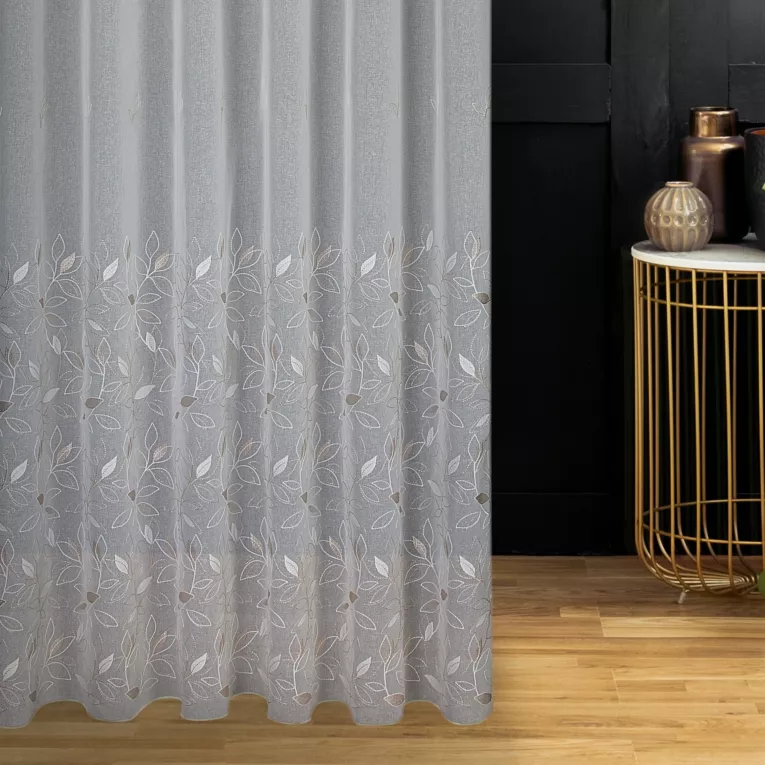 Firana szyta na taśmie 5 cm kremowo beżowa z matowej etaminy haftowanej w roślinny wzór z połyskującą nicią, wykończona obciążnikiem