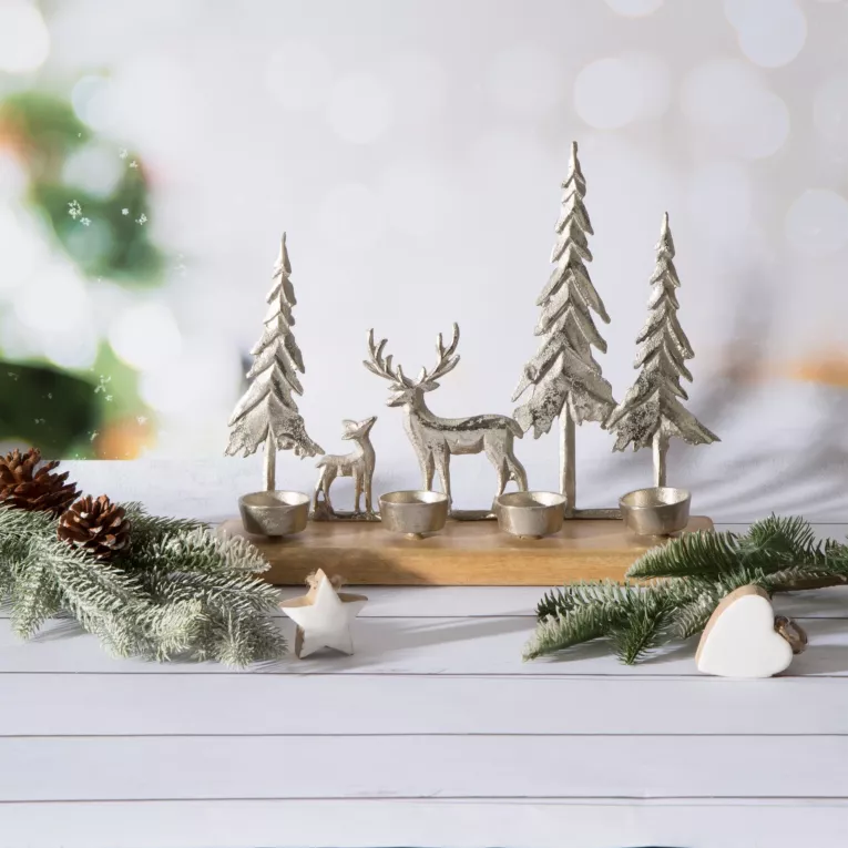 Świecznik świąteczny zdobiony srebrnymi choinkami i reniferem