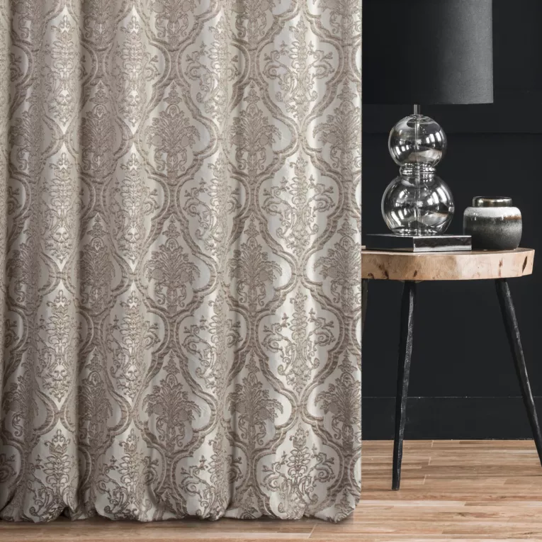 Zasłona szyta na taśmie 5 cm CASSIA beżowo srebrna z ekskluzywnej tkaniny o wypukłym wzorze ornamentowym i delikatnym połysku Italissima Eva Minge