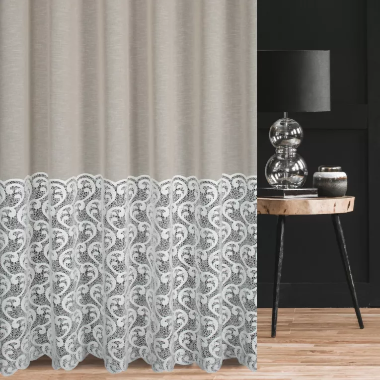 Firana szyta na przelotkach beżowo naturalna z matowej etaminy, zdobiona dołem szerokim pasem fantazyjnej aplikacji Italissima Eva Minge