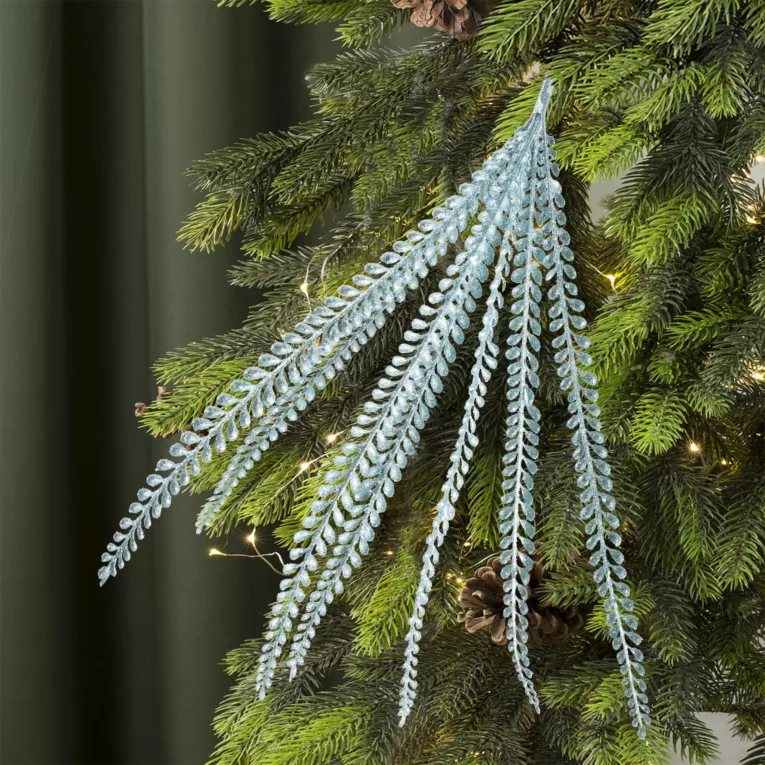 Gałązka dekoracyjna z drobnymi listeczkami obsypana iskrzącym brokatem