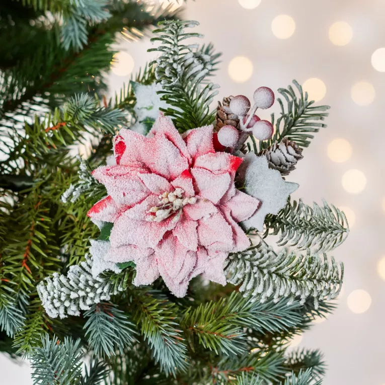 Świąteczny kwiat dekoracyjny z gałązkami obsypany śniegiem
