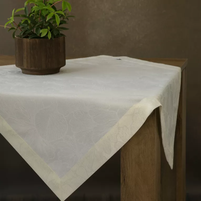 Bieżnik na stół kremowy 85x85 cm LILIAN z delikatnym wzorem liści z tkaniny przeplatanej złotą nicią z elegancką podwójną listwą