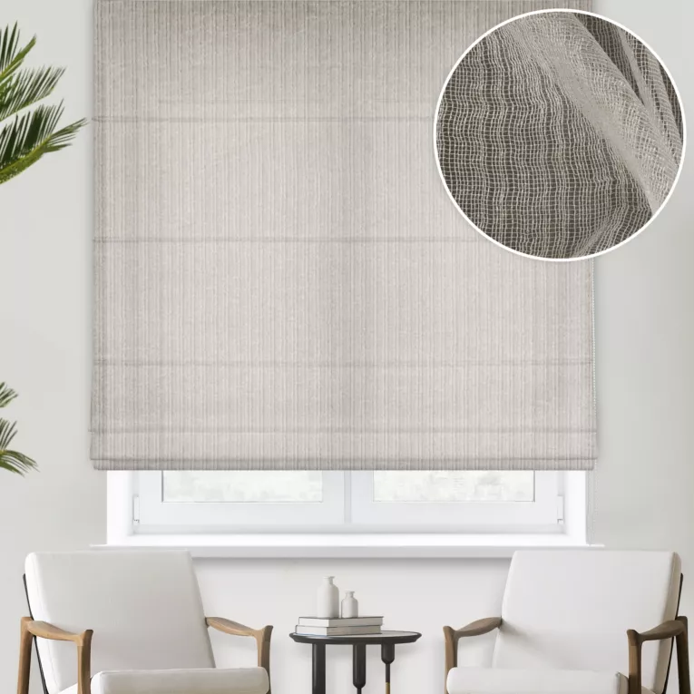 Roleta rzymska beżowa z półmatowej kreszowanej tkaniny, w nieregularne, cienkie, pionowe pasy, wykończona obciążnikiem