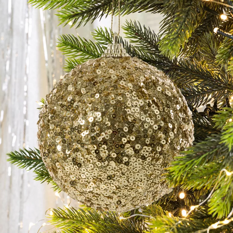 Bombka choinkowa oprószona lśniącymi złotymi cekinami