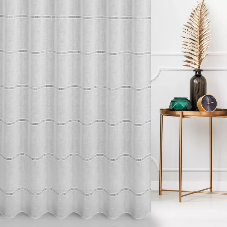 Firana szyta na przelotkach biała z matowej tkaniny o wyglądzie lnu przetykanej ażurowymi paskami, wykończona obciążnikiem