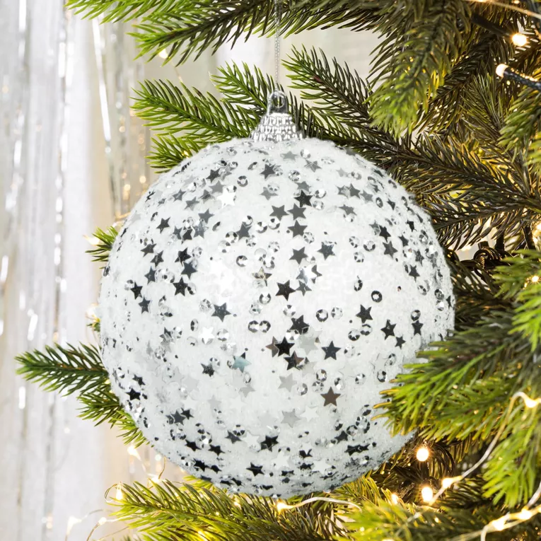 Bombka choinkowa oprószona  i srebrzystymi gwiazdkami i kryształkami