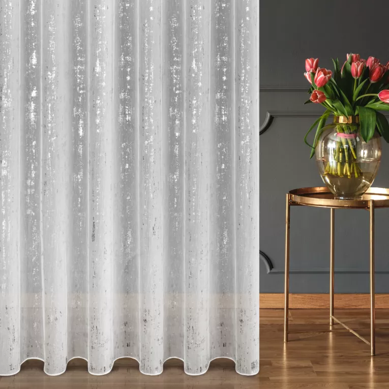 Firana szyta na taśmie 5 cm biało srebrna z tkaniny typu ADEN z efektem deszczyku, zdobionej niereguralnym srebrnym nadrukiem, wykończona obciążnikiem