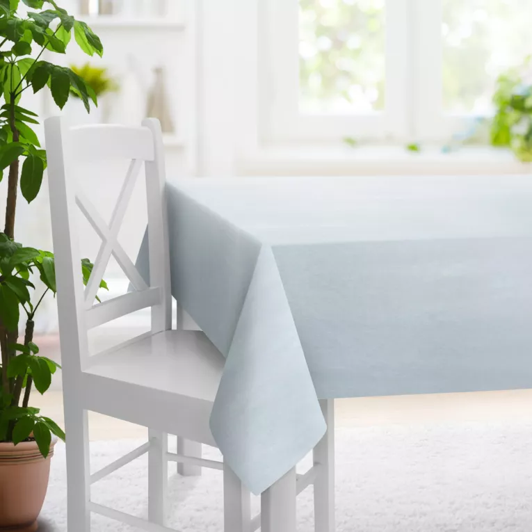 Obrus szyty błękitno jasnoszary z półprzezroczystej tkaniny o wyglądzie drobnego deszczyku i delikatnym połysku, wykończona obciążnikiem