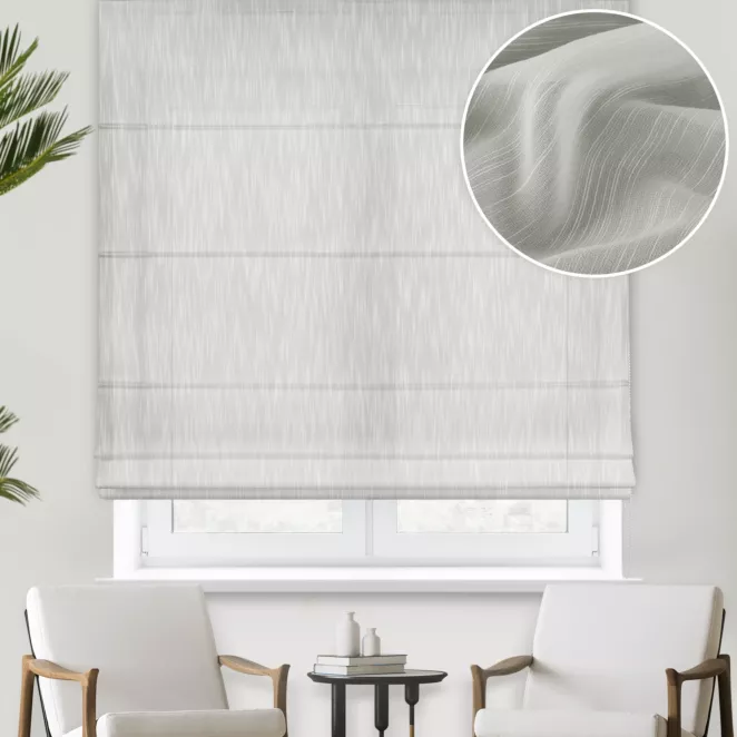 Roleta rzymska kremowa z delikantej, lejącej tkaniny z efektem deszczyku w postaci pionowych, nieregularnych linii, wykończona obciążnikiem