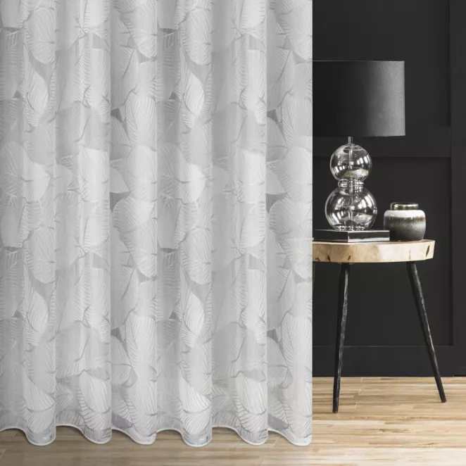 Firana szyta na taśmie 5 cm biało srebrna z tkaniny typu BATYST z delikatnie połyskującym nadrukiem w kształcie liści po całości tkaniny, wykończona obciążnikiem