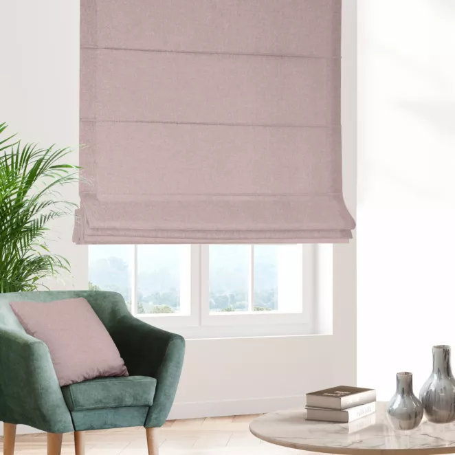 Roleta rzymska pudrowo różowa o naturalnym charakterze, z widocznym, ozdobnym splotem