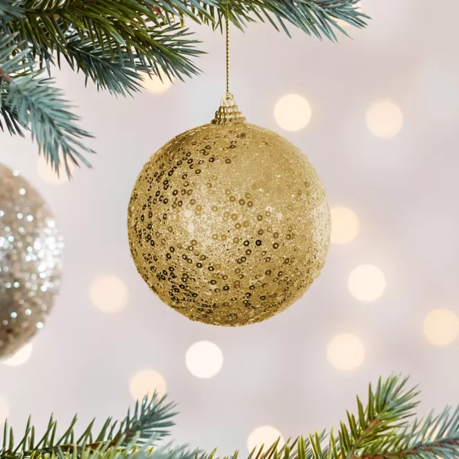Bombka choinkowa obsypana lśniącym brokatem i cekinami