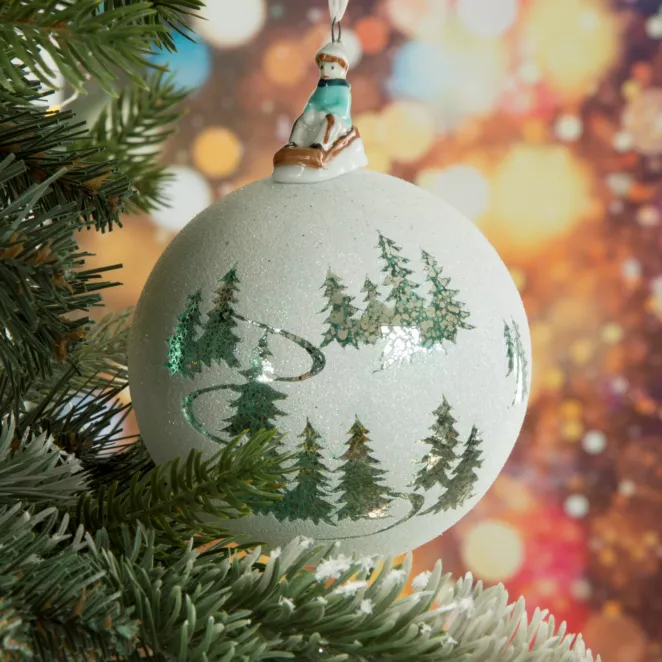 Bombka szklana  zwieńczona szklaną figurką chłopczyka na sankach