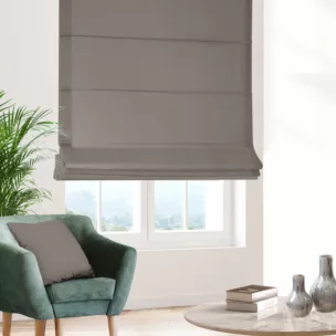 Roleta rzymska beżowa z gładkiej tkaniny zaciemniającej typu dimout wykończona obciążnikiem