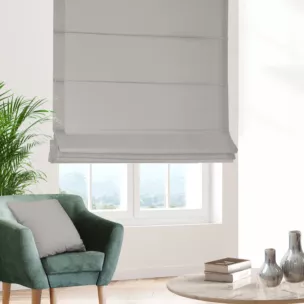 Roleta rzymska jasnobeżowa z gładkiej tkaniny zaciemniającej typu dimout wykończona obciążnikiem