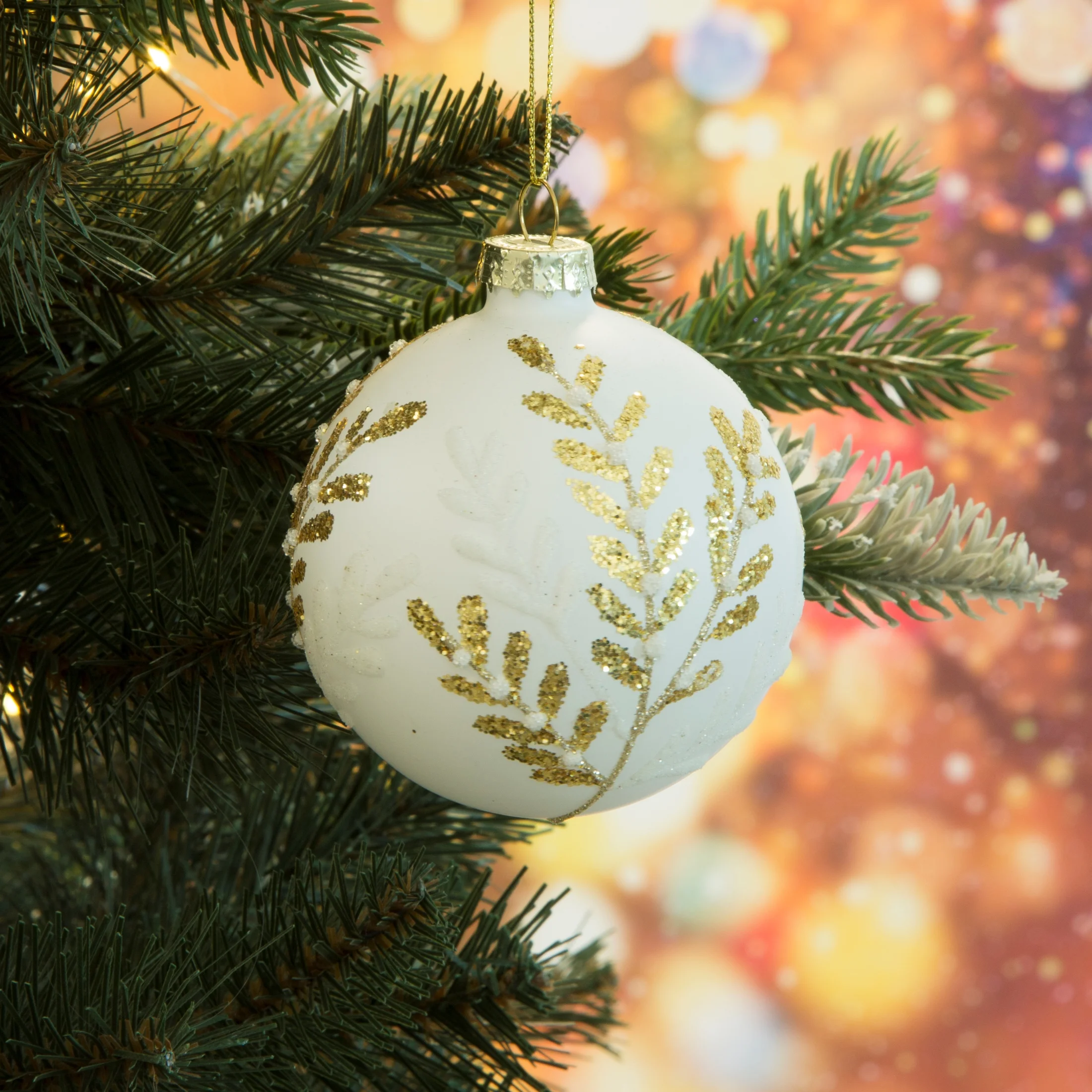 Szklana bombka choinkowa z wytłaczanym wzorem gałązek wykończona lśniącym brokatem | eurofirany